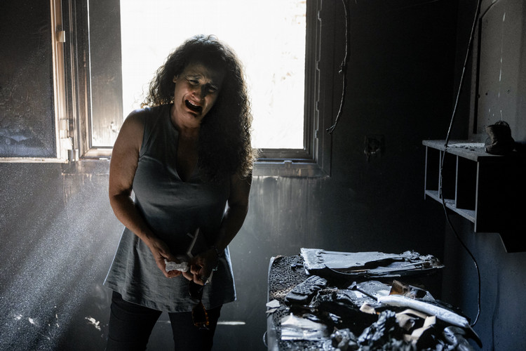 Photo by Evelyn Hockstein depicting Hadas Kalderon cries in the burned-out remains of her mother’s home, following a deadly attack by Hamas gunmen from the Gaza Strip on Kibbutz Nir Oz, in southern Israel, Oct. 3, 2023. Three members of her family, two children Erez and Sahar, and their father, Ofir, have been kidnapped and her mother and niece were killed. 