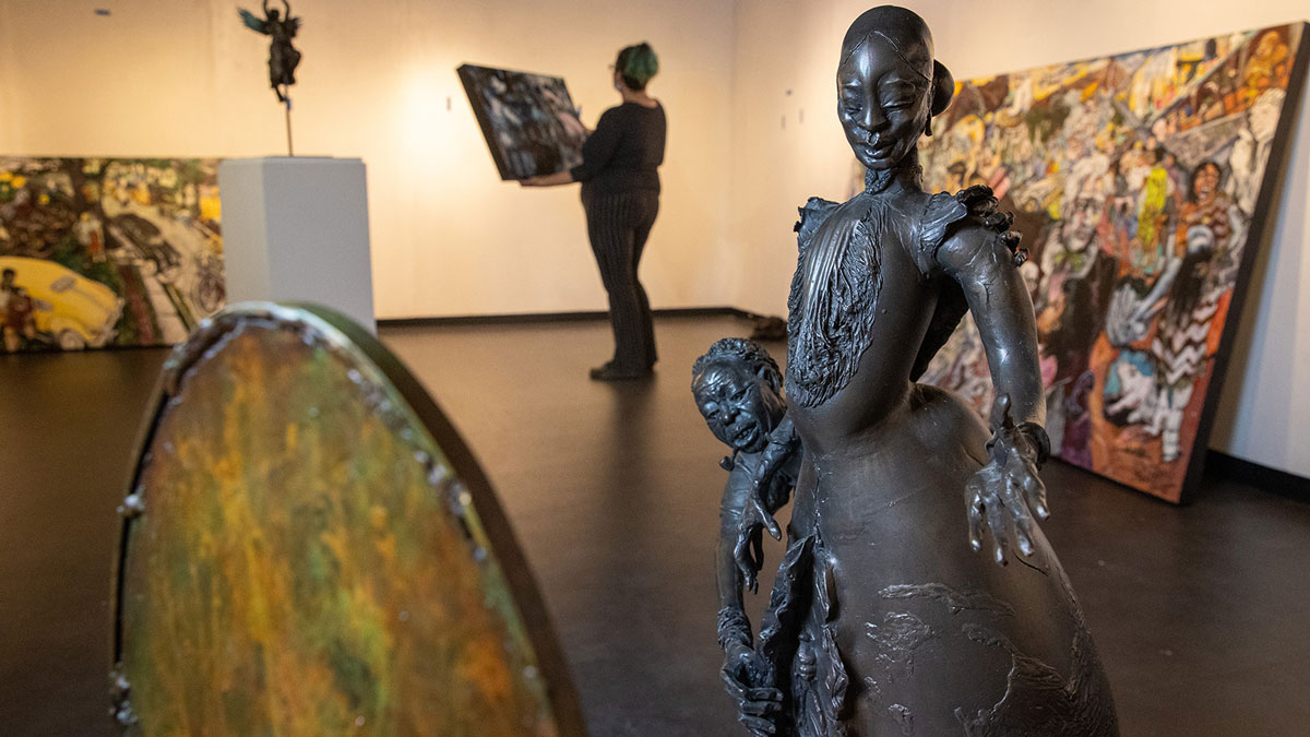 T Lance, Sharp Museum curator of exhibits, sets up artist Preston Jackson’s “Don’t Play Blues After Midnight” with Jackson’s sculpture “Dressin’ Miz. Eve” in the foreground. Jackson’s exhibition “Here We Are” begins Dec. 5. (Photo by Russell Bailey)