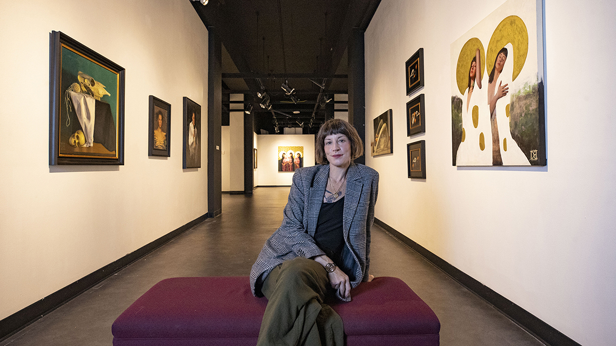 Destiny Bowmen in the hall of art gallery surounded by her paintings